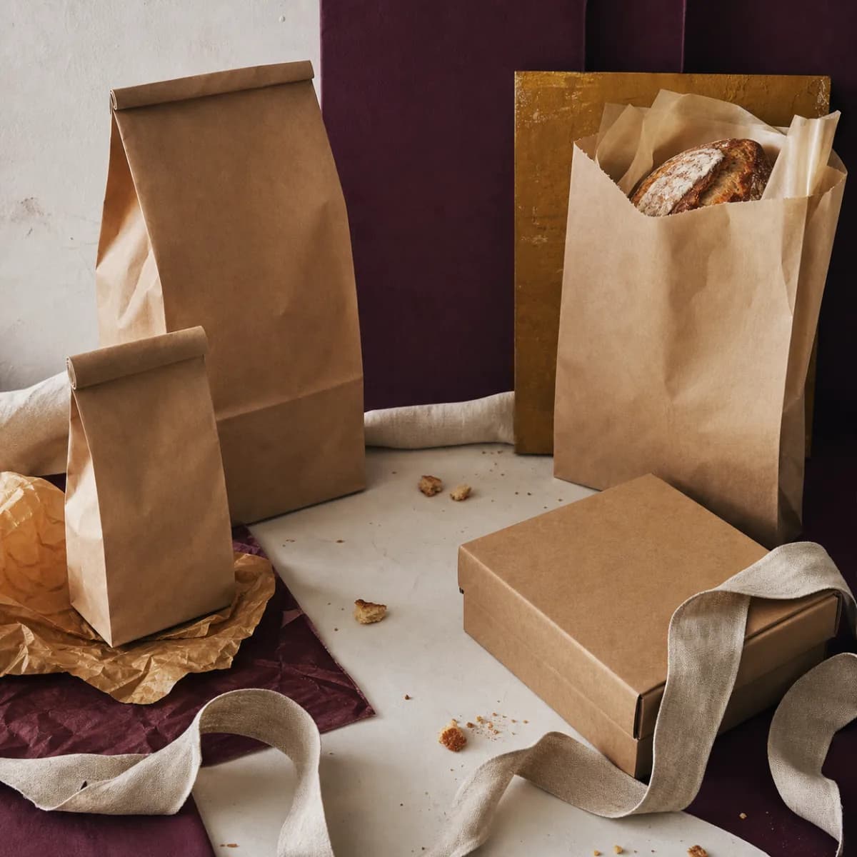 Оригинальная обложка концепта «Упаковка пекарни — Bakery Scenes»: крафт-пакеты без печати, коробка и льняная лента с крошками